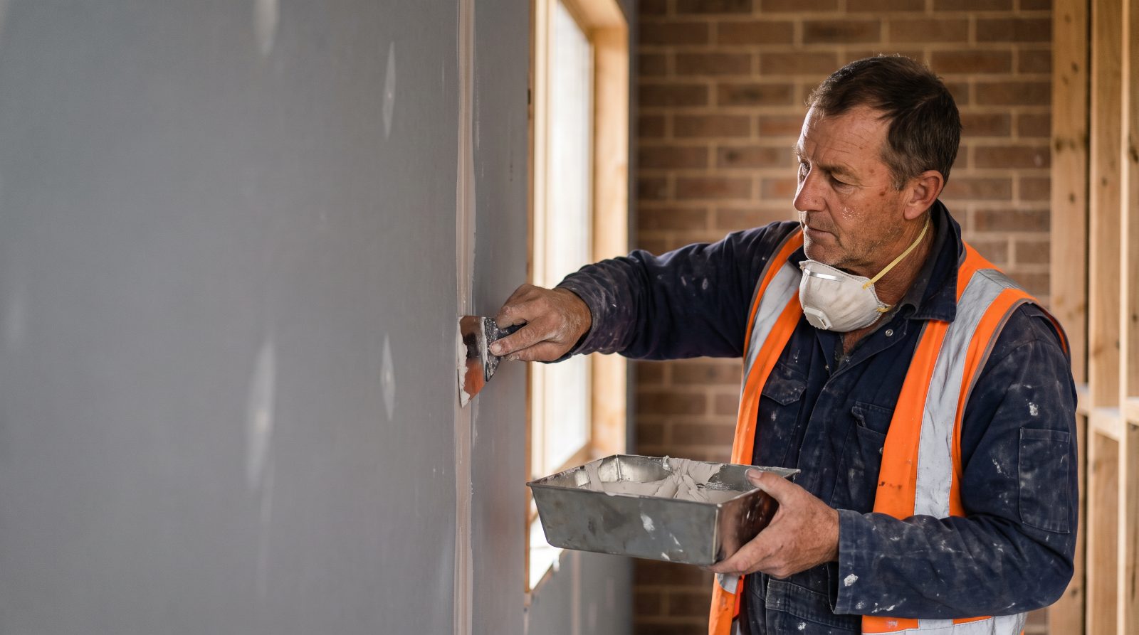 Drywall finisher taping and mudding a seam