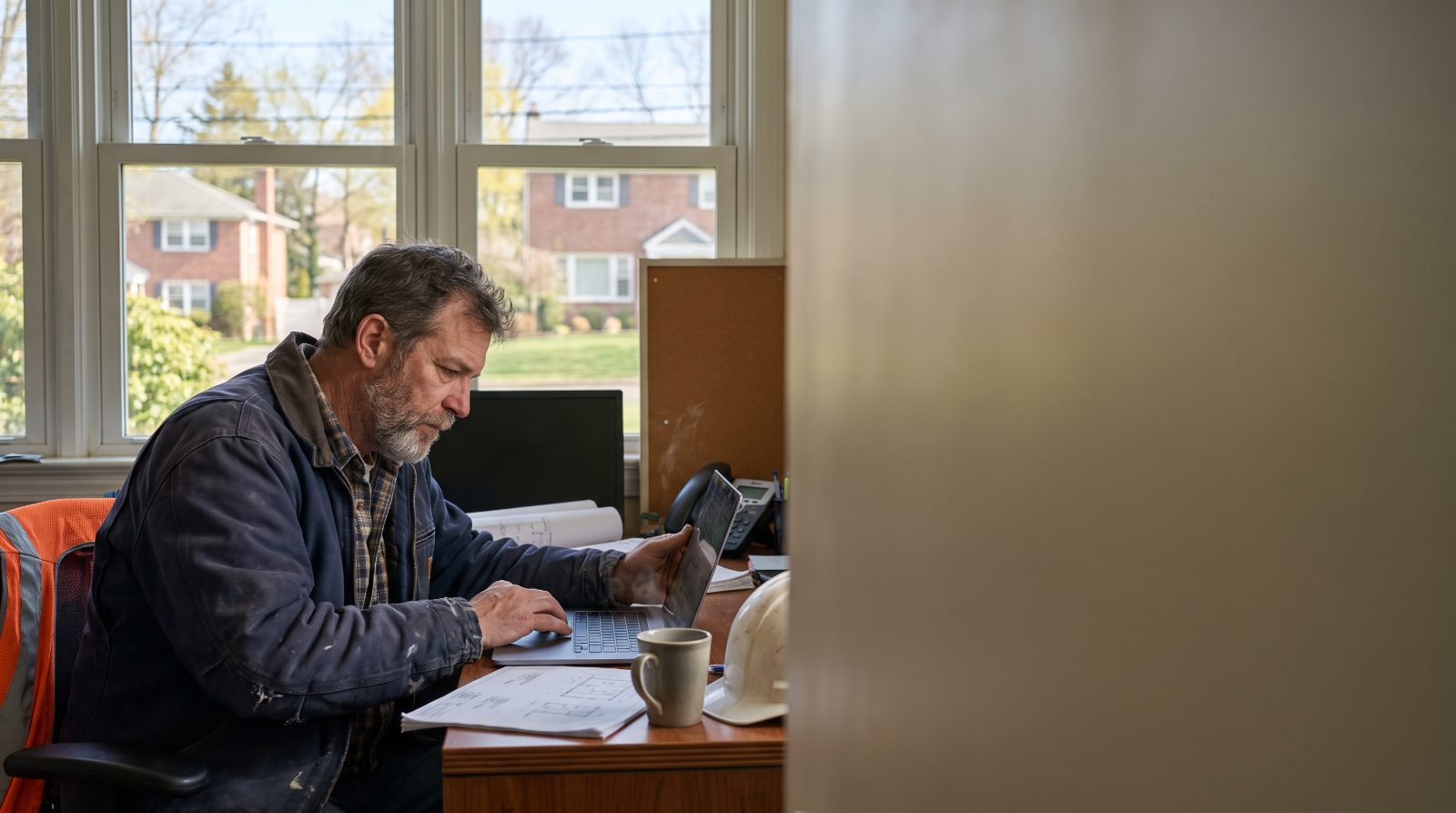 Contractor reviewing documents at a desk