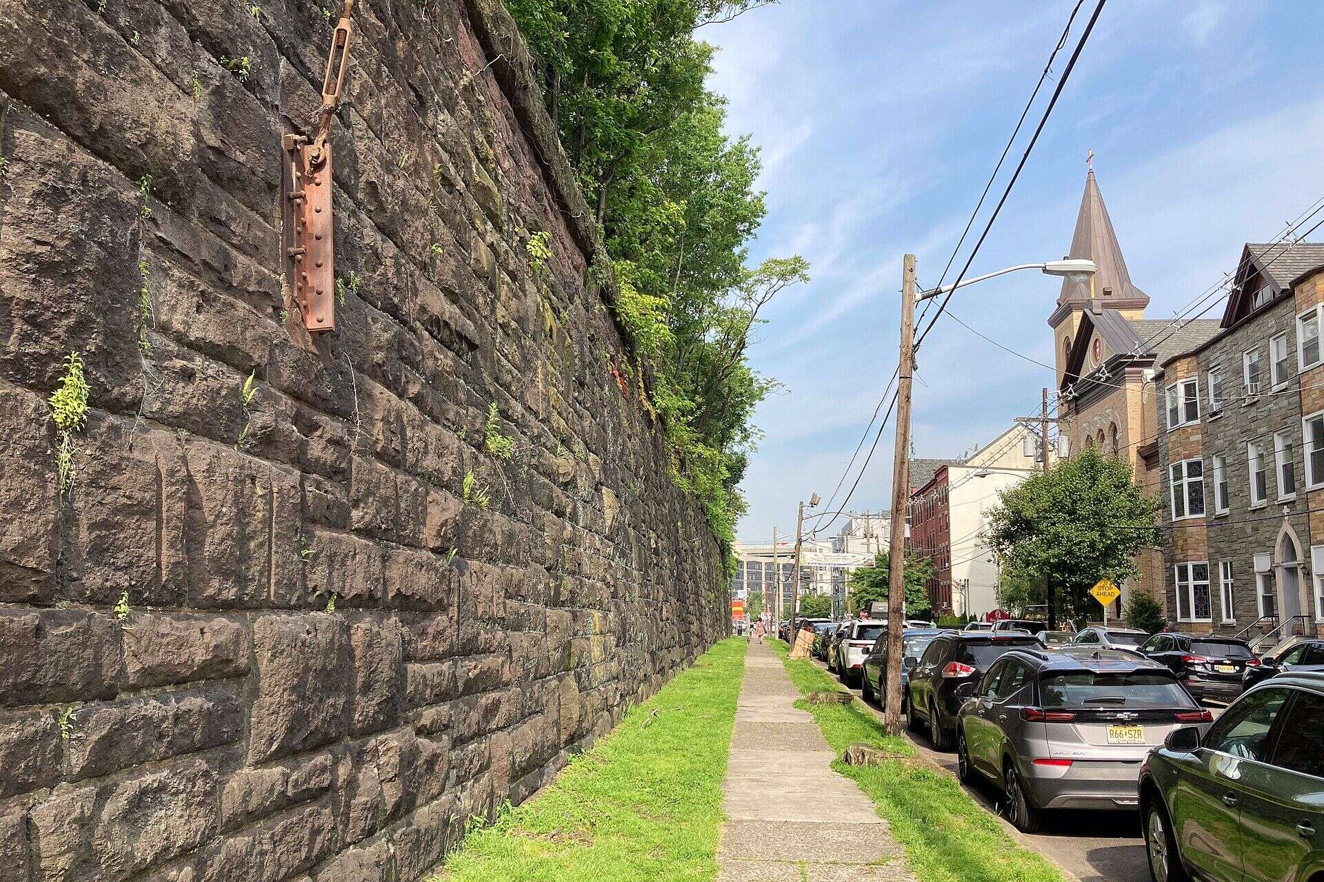The stone retaining wall of the Harsimus Stem Embankment along a downtown street in Jersey City, New Jersey